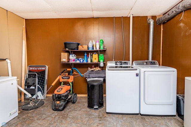 laundry area with independent washer and dryer and wood walls