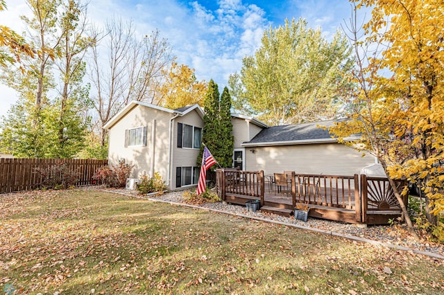 rear view of property with a deck and a lawn