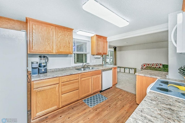 kitchen with white appliances, sink, a textured ceiling, light hardwood / wood-style floors, and light brown cabinets