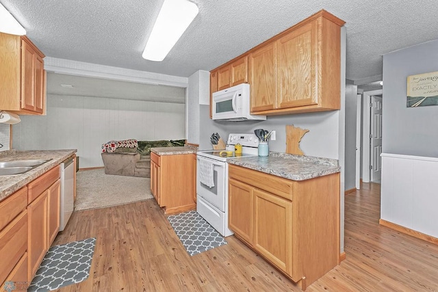 kitchen featuring light hardwood / wood-style floors, a textured ceiling, sink, and white appliances