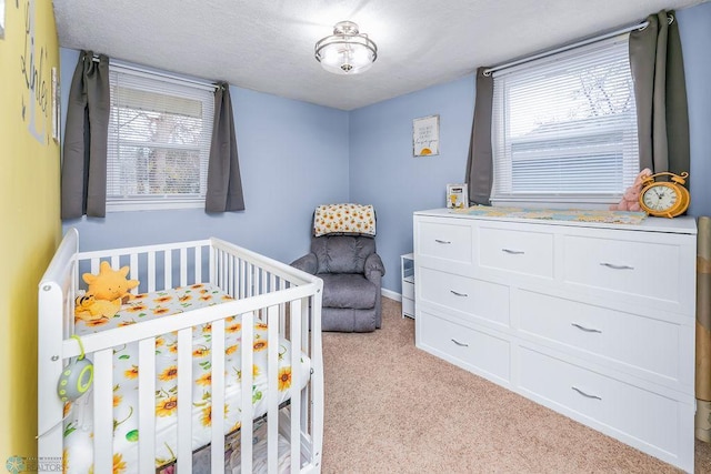 bedroom featuring a nursery area, light carpet, and multiple windows