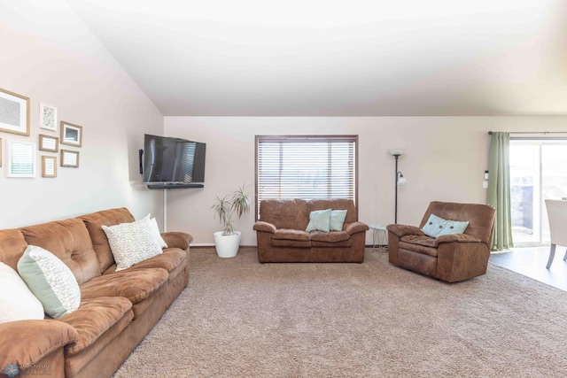 carpeted living room with plenty of natural light and vaulted ceiling