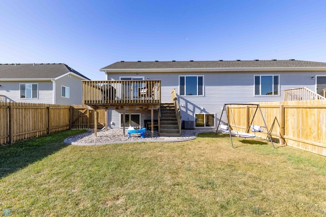 rear view of property featuring a wooden deck and a yard