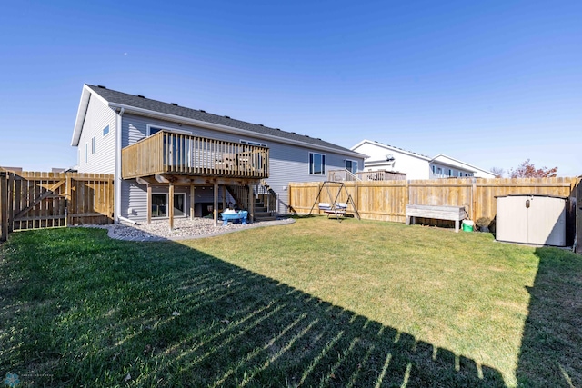 rear view of house with a yard, a deck, and a storage unit