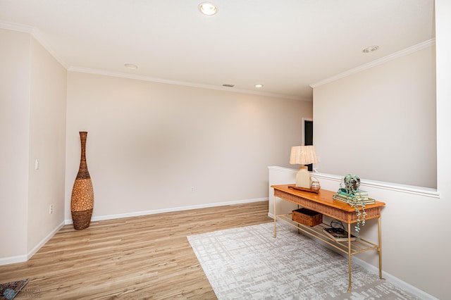 sitting room with ornamental molding and light wood-type flooring