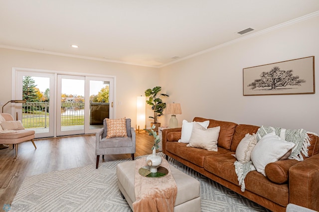 living room with ornamental molding and light hardwood / wood-style flooring