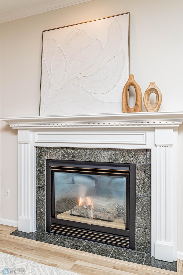 details featuring hardwood / wood-style flooring, ornamental molding, and a fireplace