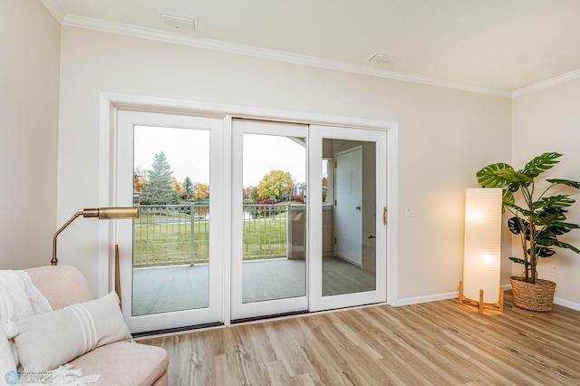 doorway featuring crown molding and light wood-type flooring