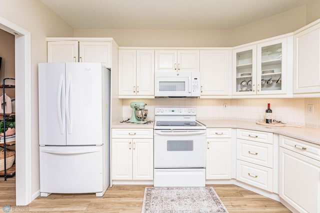 kitchen featuring decorative backsplash, light hardwood / wood-style flooring, white appliances, and white cabinets