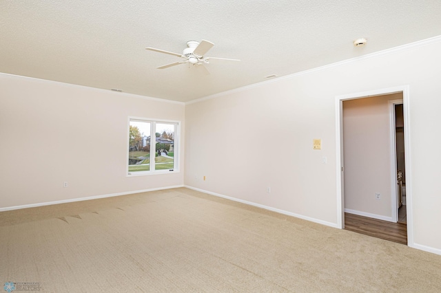 carpeted empty room with crown molding, a textured ceiling, and ceiling fan