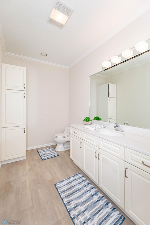 bathroom with vanity, ornamental molding, and toilet