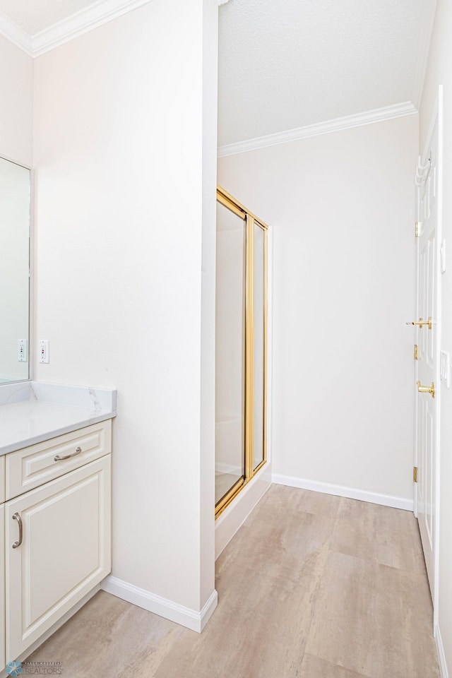 bathroom with vanity, ornamental molding, and walk in shower