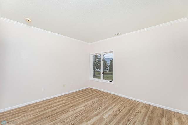 spare room featuring light hardwood / wood-style floors, ornamental molding, and a textured ceiling