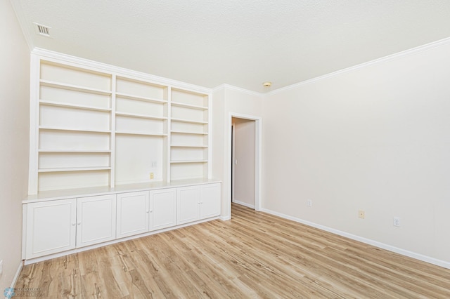 interior space with light hardwood / wood-style floors, crown molding, and a textured ceiling