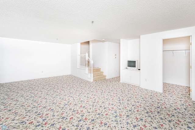 basement featuring carpet floors and a textured ceiling