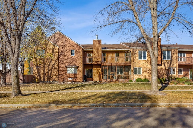 view of front of house featuring a balcony and a front lawn