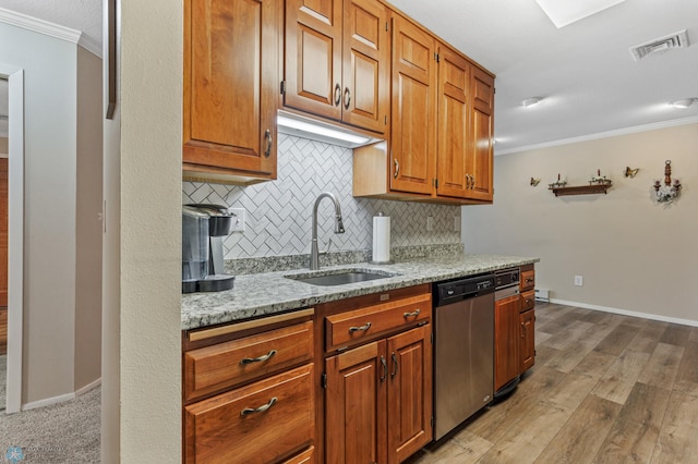 kitchen with ornamental molding, stainless steel dishwasher, sink, and light wood-type flooring