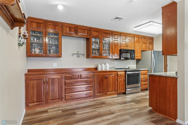 kitchen with stainless steel appliances and light hardwood / wood-style floors