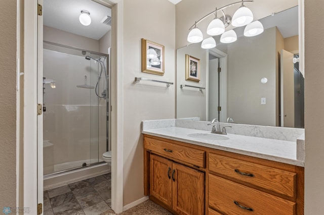 bathroom with vanity, toilet, and a shower with door