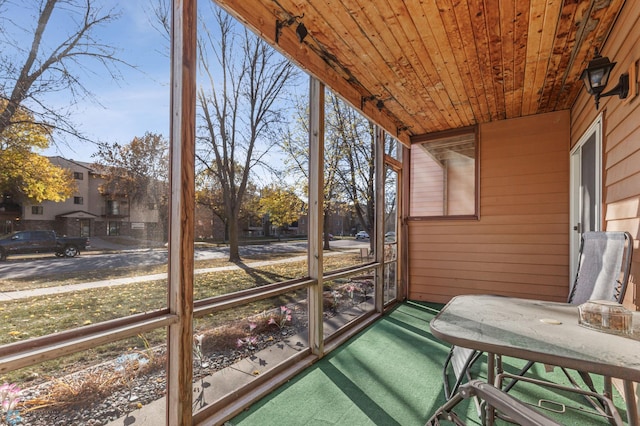 unfurnished sunroom featuring wooden ceiling and plenty of natural light