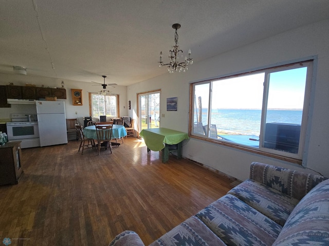 living room with a textured ceiling, a water view, ceiling fan with notable chandelier, and hardwood / wood-style flooring