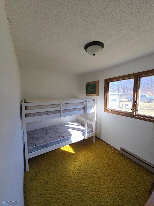 unfurnished bedroom featuring a baseboard radiator, a textured ceiling, and carpet flooring