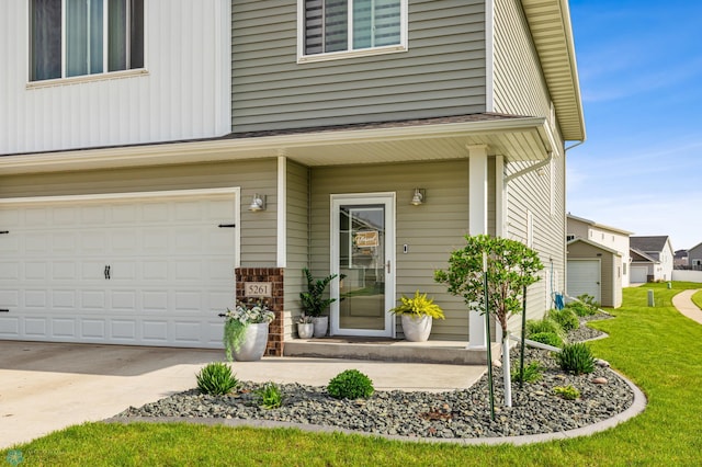 view of exterior entry with a yard and a garage