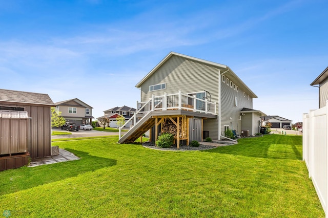 back of property featuring a wooden deck, central AC, and a lawn