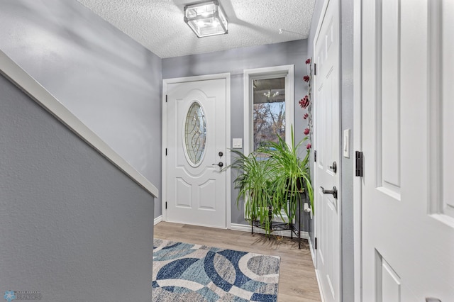 foyer with a textured ceiling and light hardwood / wood-style floors