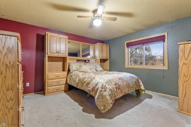 bedroom with light carpet, a textured ceiling, and ceiling fan