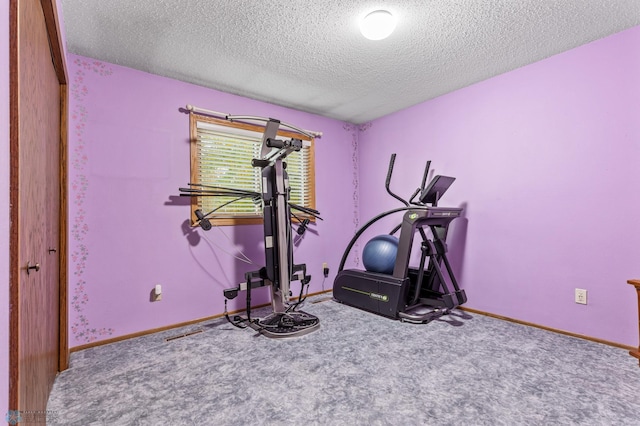 workout room featuring a textured ceiling and carpet floors