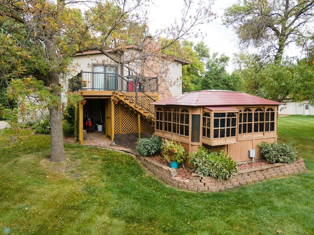 rear view of property with a wooden deck and a lawn