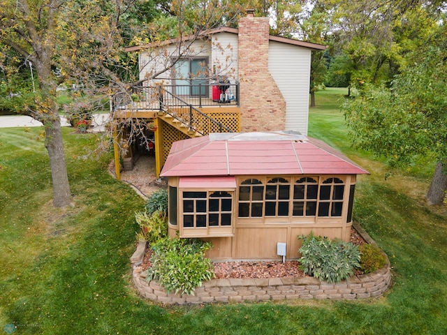 exterior space featuring a wooden deck and a lawn