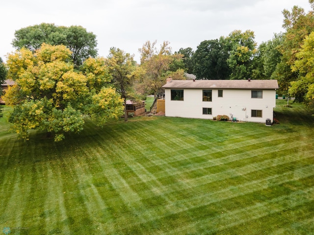 back of house featuring a deck and a lawn