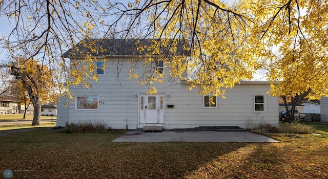 rear view of property with a patio and a yard