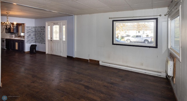 interior space featuring a baseboard heating unit, a healthy amount of sunlight, sink, and dark wood-type flooring