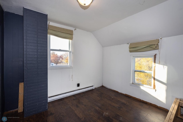 additional living space featuring a baseboard heating unit, vaulted ceiling, plenty of natural light, and dark hardwood / wood-style floors