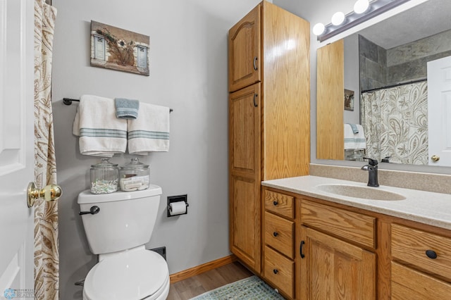 bathroom with toilet, hardwood / wood-style flooring, and vanity