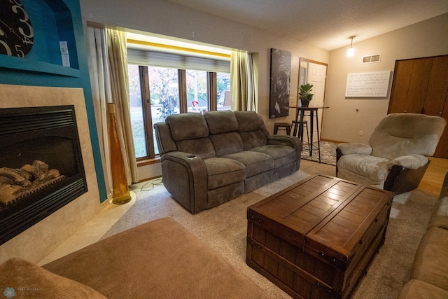 carpeted living room featuring a fireplace and vaulted ceiling