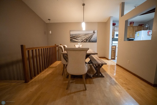 dining room featuring lofted ceiling and light hardwood / wood-style flooring