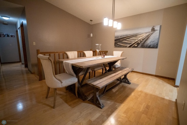 dining space featuring lofted ceiling and light wood-type flooring