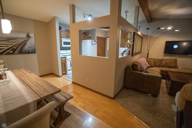 interior space with vaulted ceiling with beams and light hardwood / wood-style floors