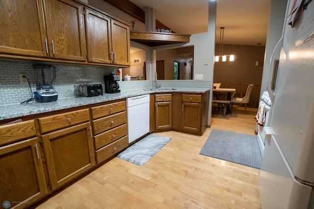 kitchen with white appliances, light hardwood / wood-style flooring, sink, and light stone counters