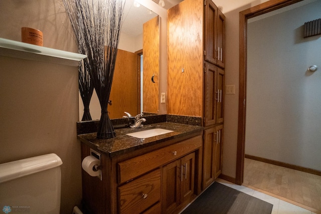 bathroom featuring toilet, vanity, and tile patterned flooring