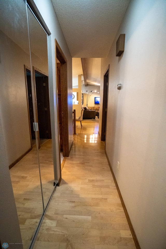 hallway featuring a textured ceiling and light hardwood / wood-style flooring