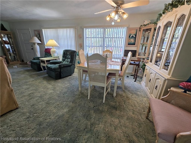 carpeted dining room with ceiling fan