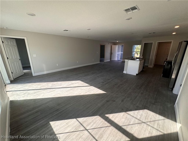 unfurnished living room with sink and dark wood-type flooring