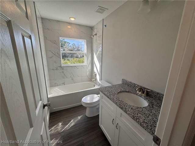 full bathroom featuring tiled shower / bath combo, wood-type flooring, vanity, and toilet