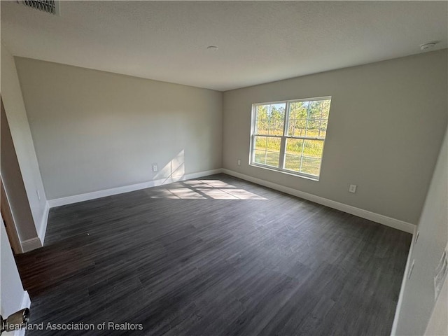 spare room with dark hardwood / wood-style floors