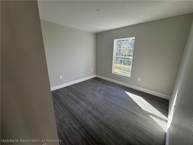 spare room featuring dark wood-type flooring